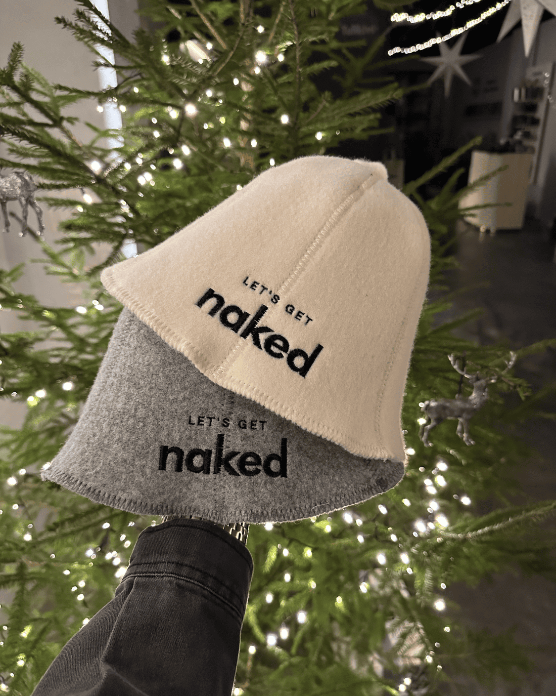 Pirts cepures no vilnas baltā un pelēkā krāsā ar tekstu "Lets get naked"